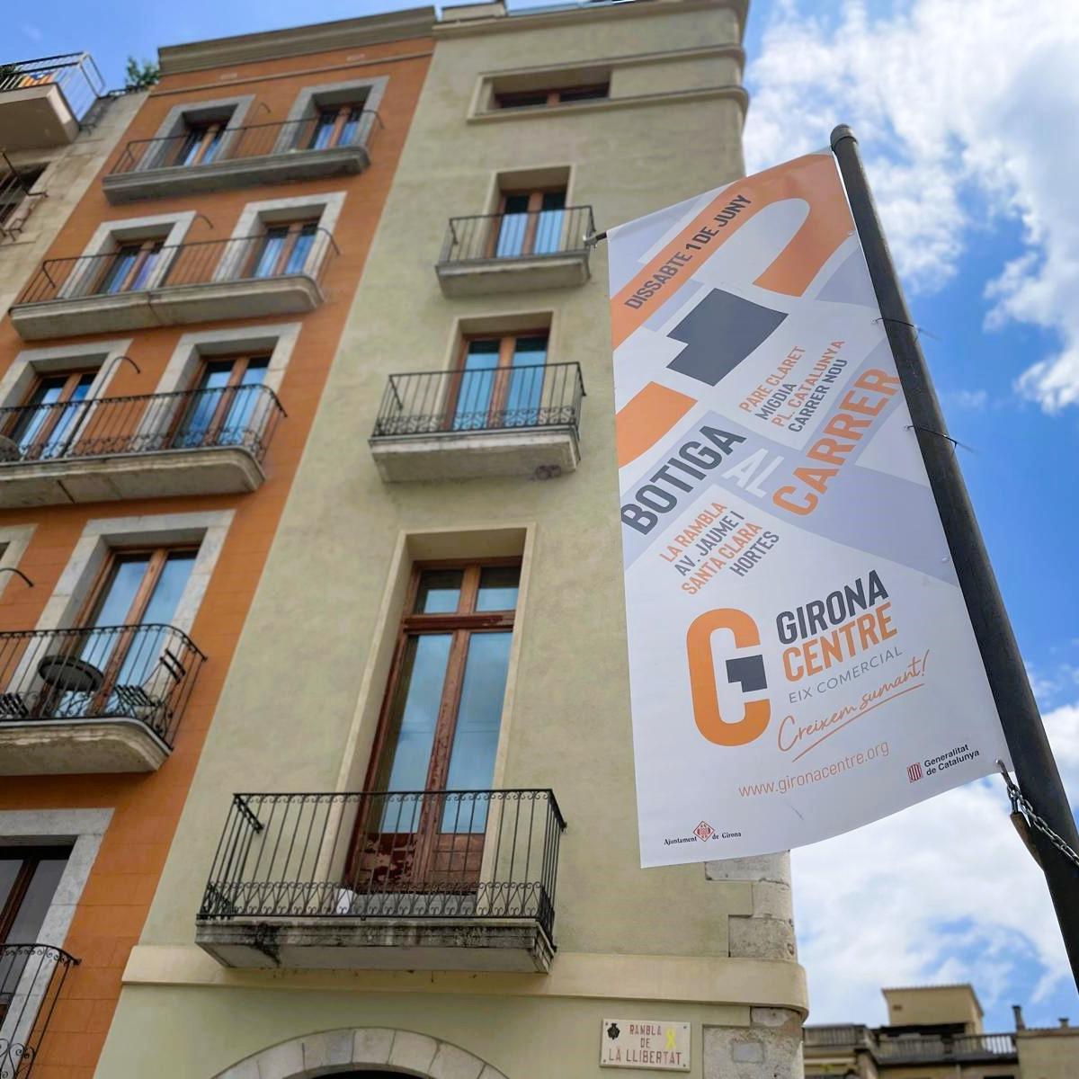 Banderola al carrer anunciant la botiga al carrer